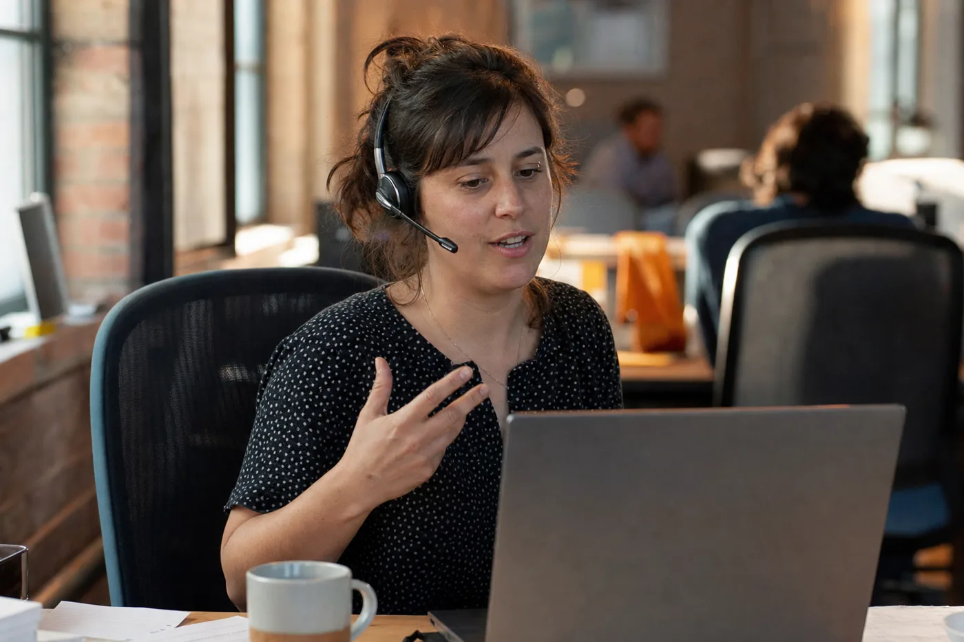 Employee practicing an AI coaching for employees roleplay conversation at her desk with a headset