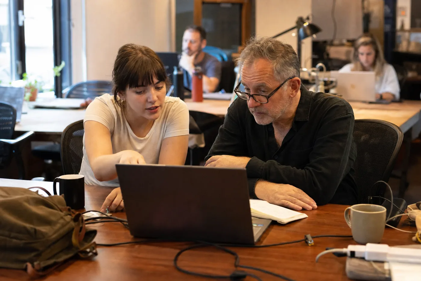 New hire and manager working through an AI onboarding training plan together at a bright office desk