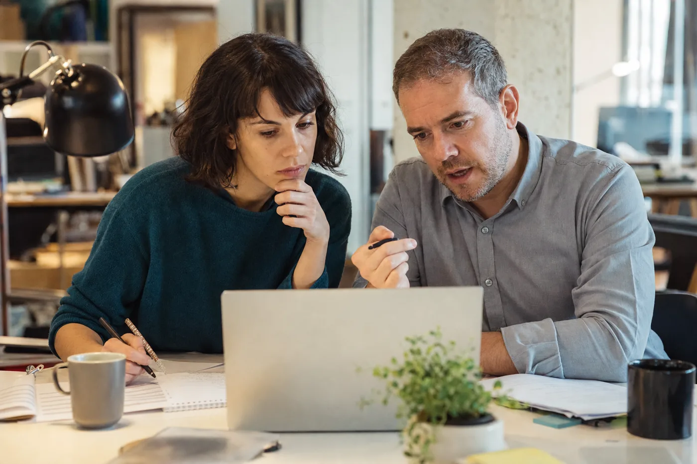 Coworkers using AI study mode on a laptop during a corporate training session, working through a problem instead of reading an answer