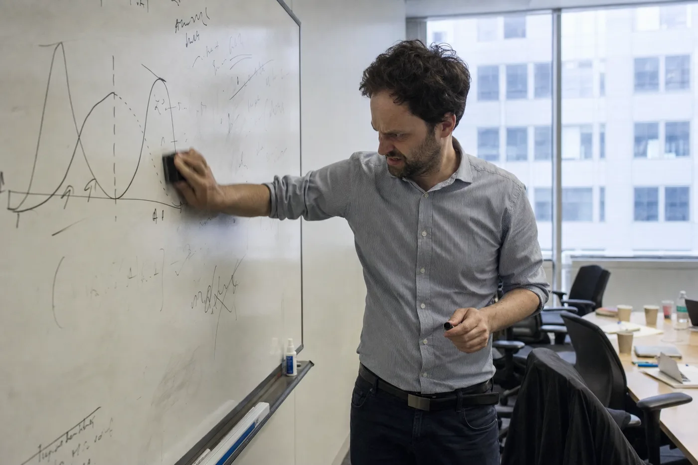 An employee reworking a solution on an office whiteboard, the productive struggle that sycophantic AI removes