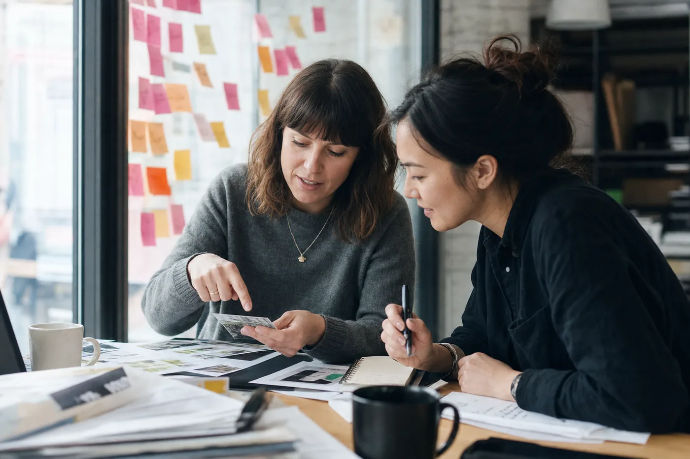 Two coworkers actively working through a problem together with sticky notes during interactive training
