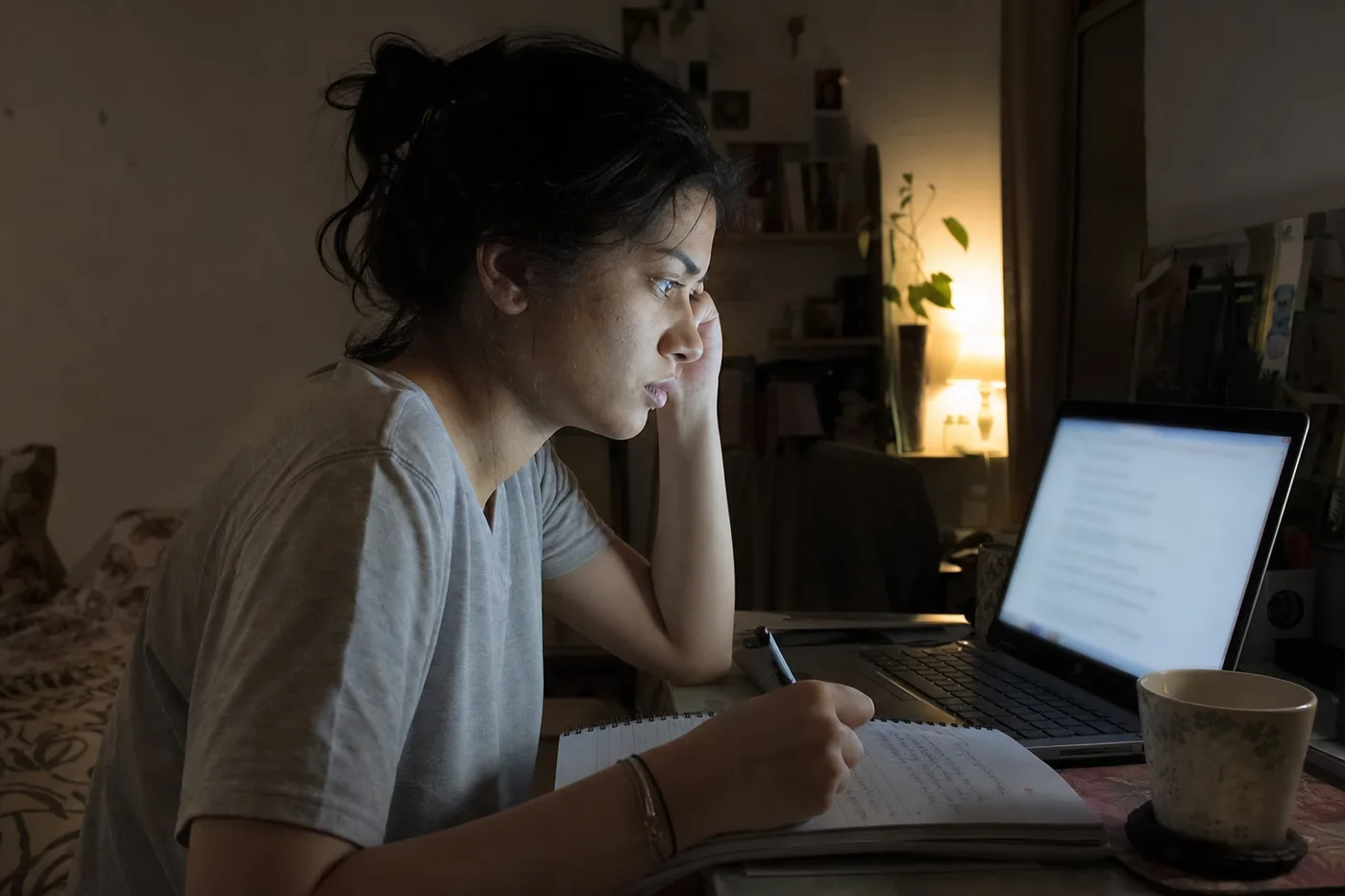 A student studies alone at night with a laptop, the scenario custom AI tutors were built for