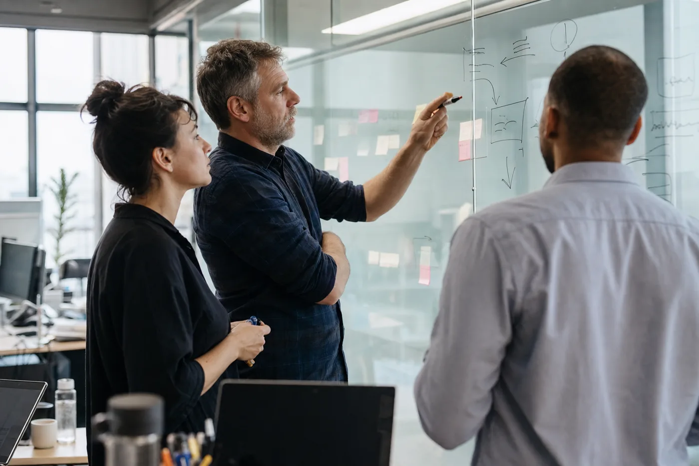 An L&D team planning an enterprise AI tutor rollout around a whiteboard in a bright corporate office
