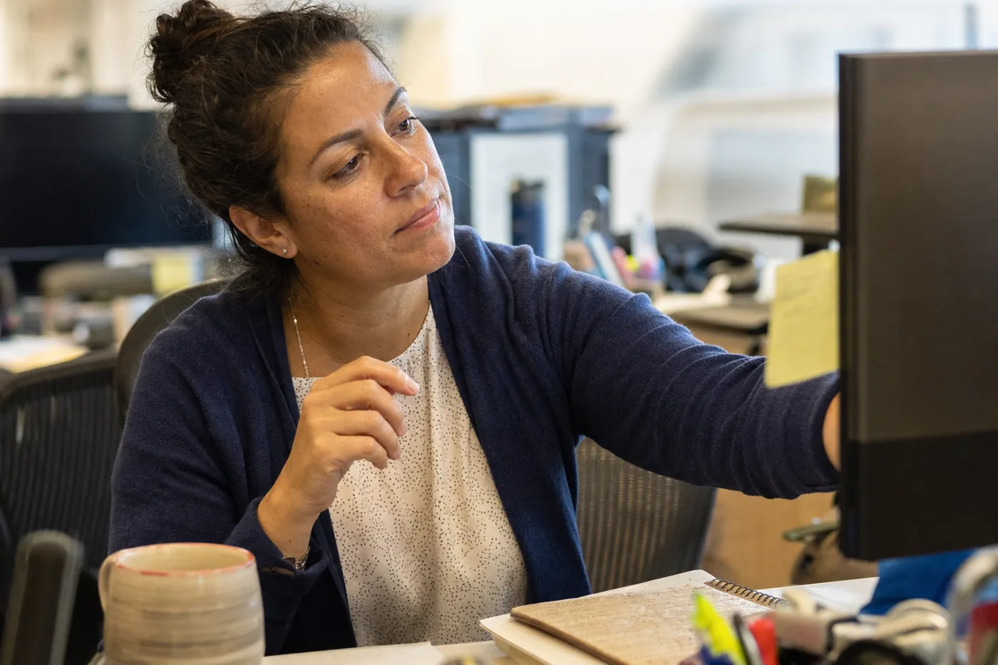 An employee at her desk applying a newly learned skill the week after training, an example of training transfer on the job