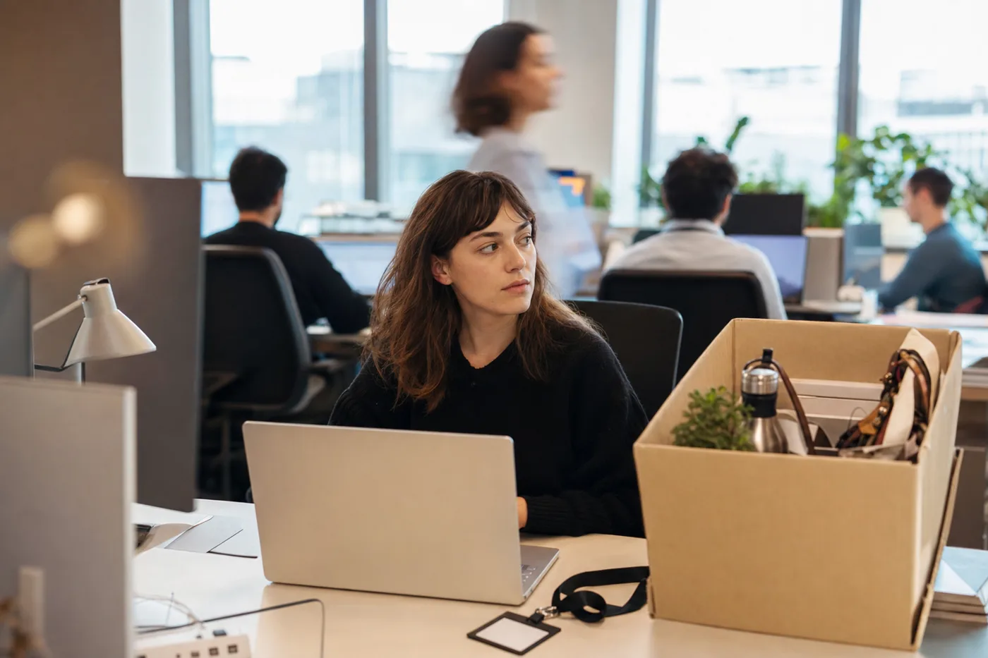 New employee sitting alone at an office desk in their first week, a scene that captures why new hires quit early